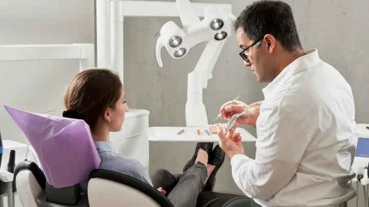 Dentist helping a patient in the dentist chair.