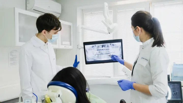 Dentists showing patient x ray of her teeth