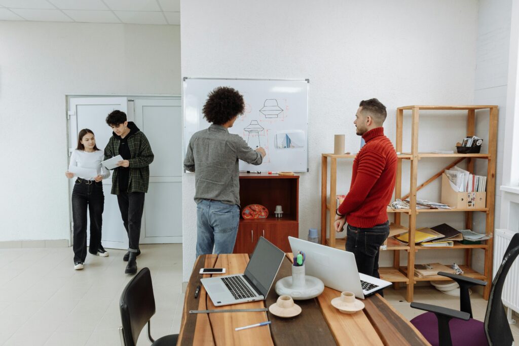 A Person Discussing with a Man a Drawing on a White Board