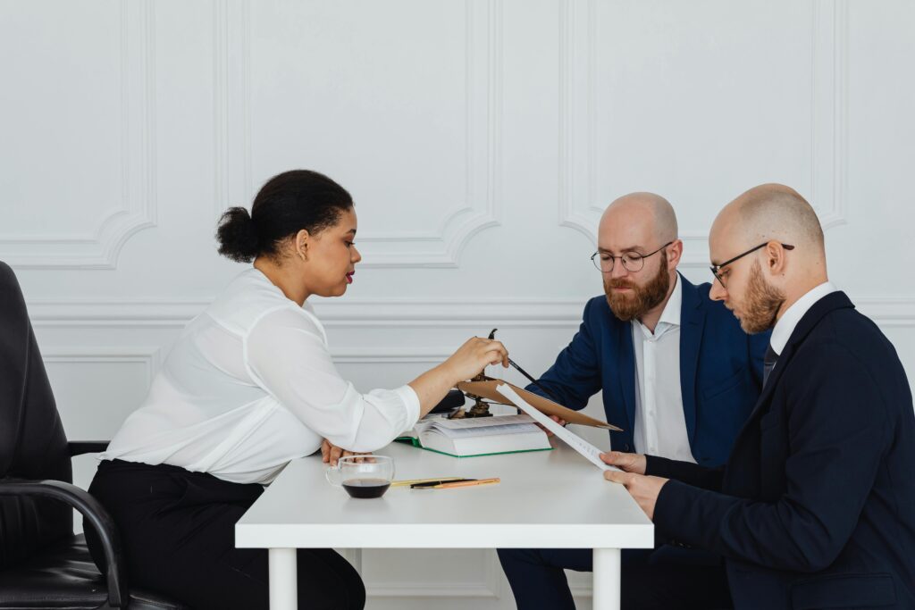 A Woman Showing Documents to her Coworkers