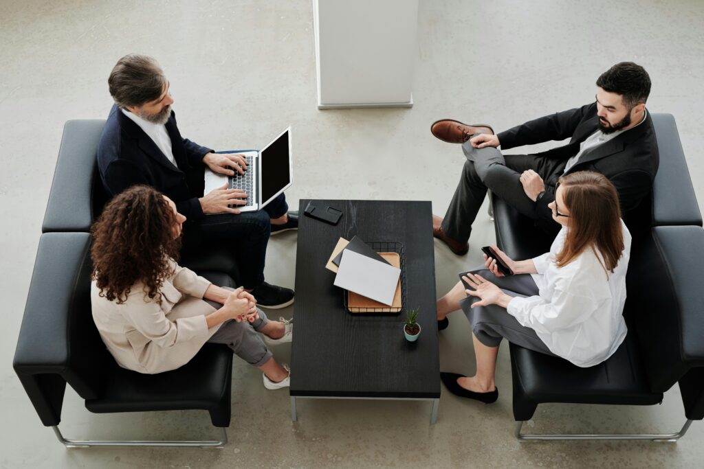 People Sitting on Black Leather Sofa Having a Conversation